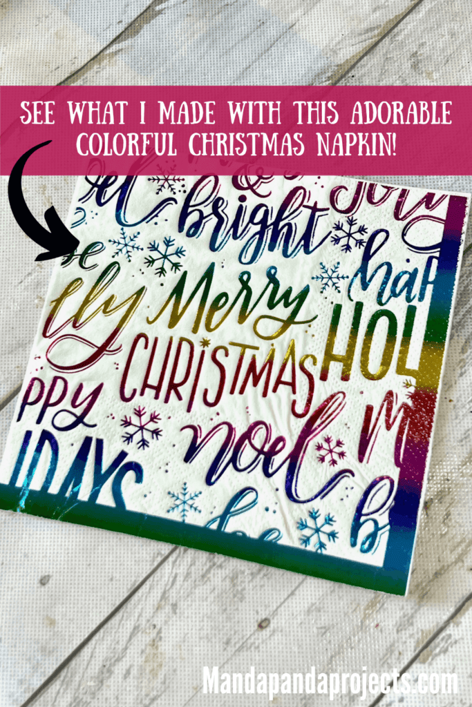 Colorful rainbow Christmas napkin with lots of holiday phrases and words written on it.