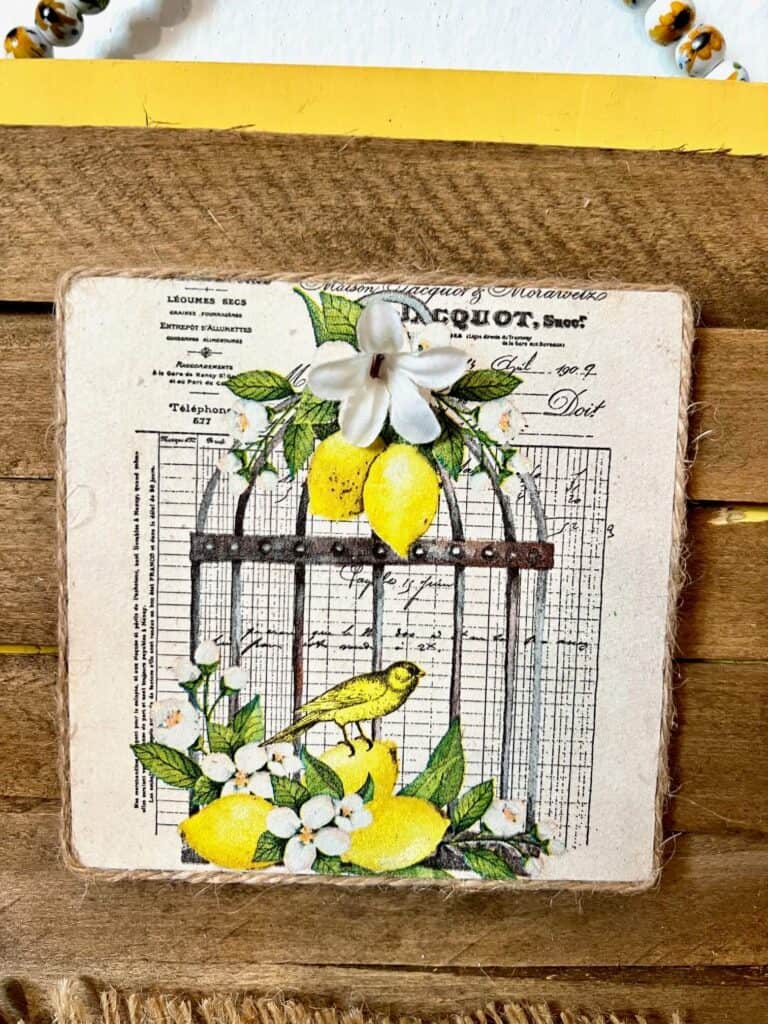 A napkin with a birdcage, with lemons, a bird, and small white flowers.
