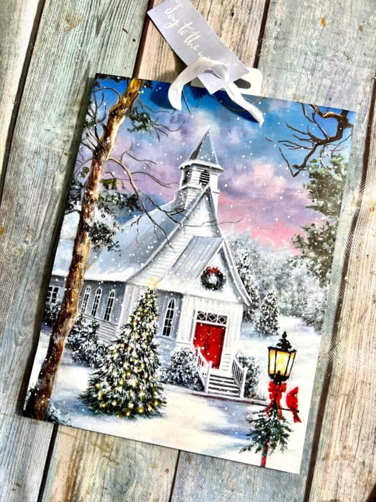 A gift bag with a Christmas Church scene on it.