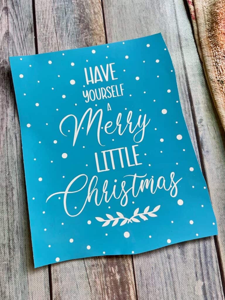The vinyl stencil that says "Have yourself a merry little christmas" that was reverse weeded on light blue vinyl.