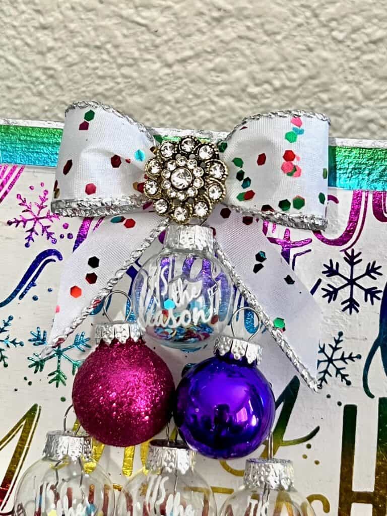 Close up of the colorful small bow at the top of the tree with a totally dazzled bling in the center.