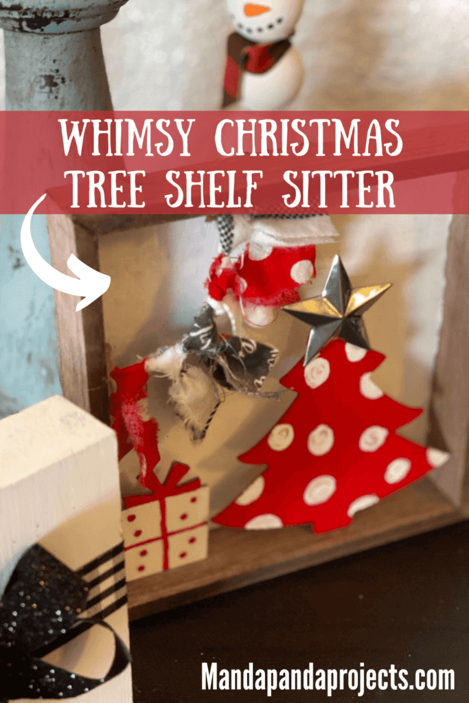 Whimsy Christmas Tree Shelf sitter that is small enough to fit on a tiered tray with a Dollar Tree wood Christmas tree painted red with white polka dots, a small wood present under the tree and a fabric garland in the top left corner. 