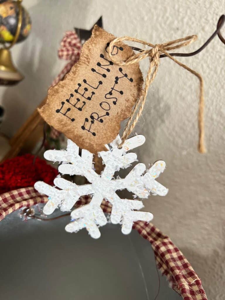 A kraft paper hangtag that says "feeling frosty" tied to the wire with a snowy white snowflake.