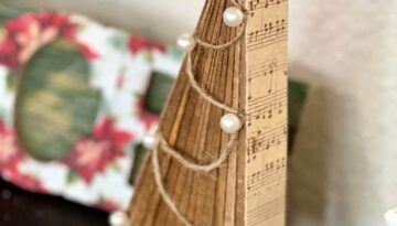 DIY standing Christmas tree decor with wooden shims, music sheet scrapbook paper, twine and pearls ornaments, a metal star and a leopard print trunk and stand made with jenga blocks.