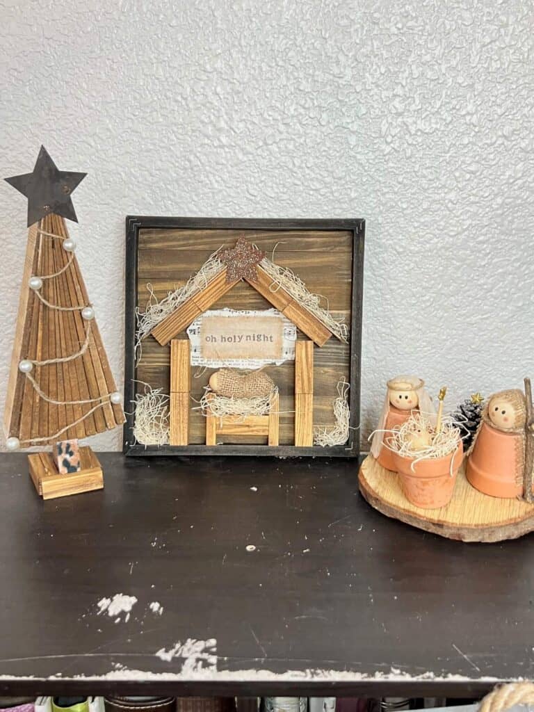 A wooden shim christmas tree on the left, the DIY Rustic Nativity Set in the middle, and the Terra cotta pot nativity set on the right.