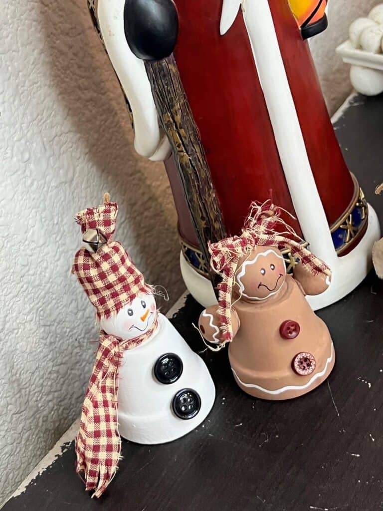 Terra Cotta Pot Gingerbread and snowman diy christmas decor made with mini terra cottas, wood bead heads, homespun fabric scarfs, and buttons with simple hand painted faces.