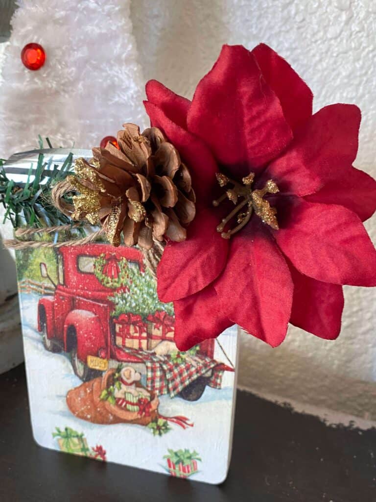 Close up of the faux poinsettia at the top with the glitter gold pine cone.