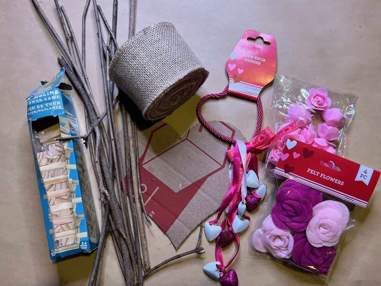 Supplies needed to make a Valentines Day heart out of sticks and cardboard and jenga blocks with Felt roses.