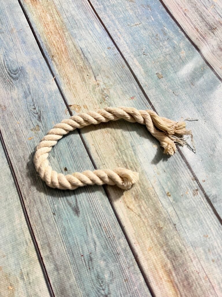 White nautical rope piece sitting on a table.