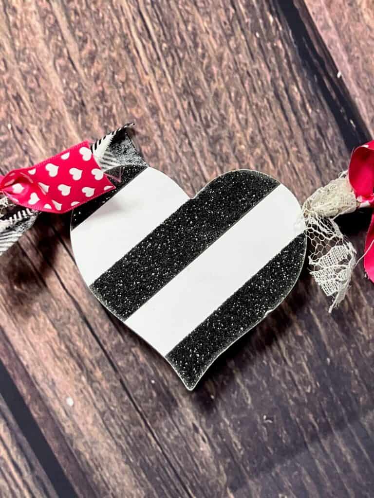 Wood heart with black and white striped glitter scrapbook paper.