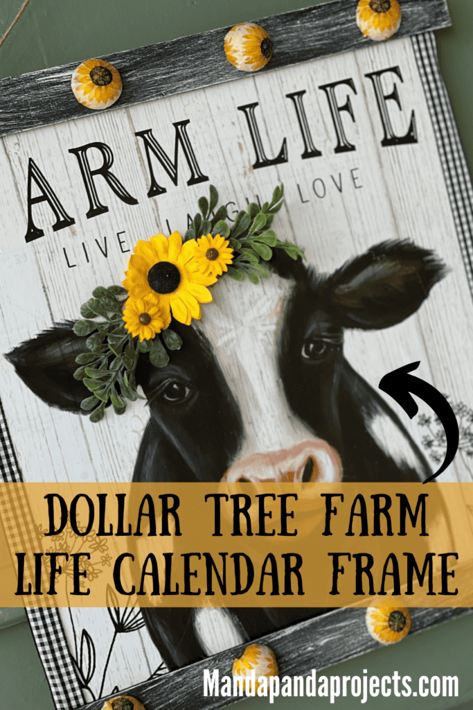 A DIY Decor frame with the Dollar Tree Farm Life Cow Print Calendar with sunflowers in the cows head, and sunflower beads on the top and the bottom of the frame, hangin with a twine hanger.