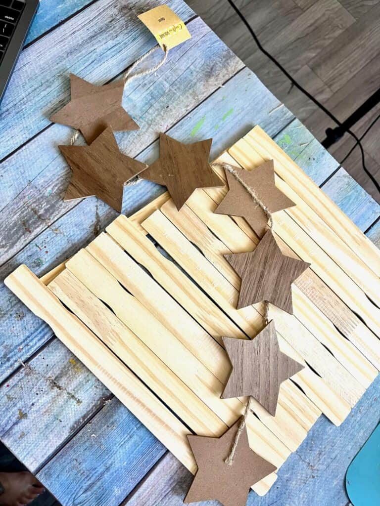 Paint stir sticks and a wood star garland sitting on a table.