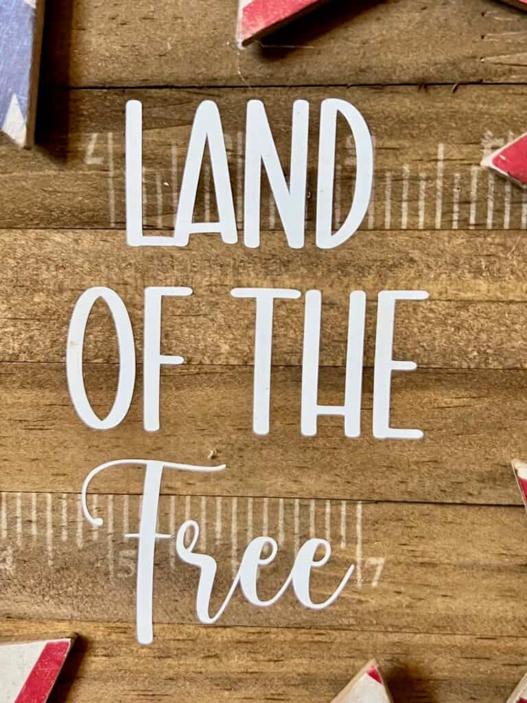 Land of the free in white vinyl in the center of my wreath sign.