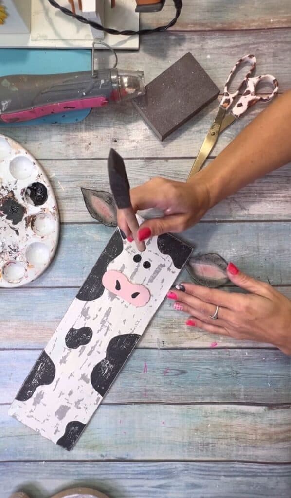 Paint the cows eyes using the round end of a foam brush dotted in black paint.