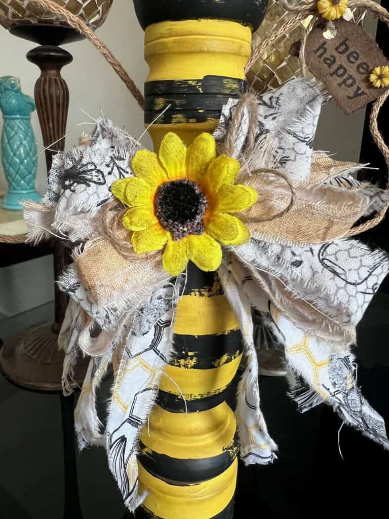 A big messy fabric bow with a sunflower in the center.