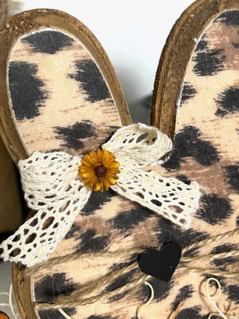 A cute and simple white lace bow with a sunflower on the top of the bunny head.