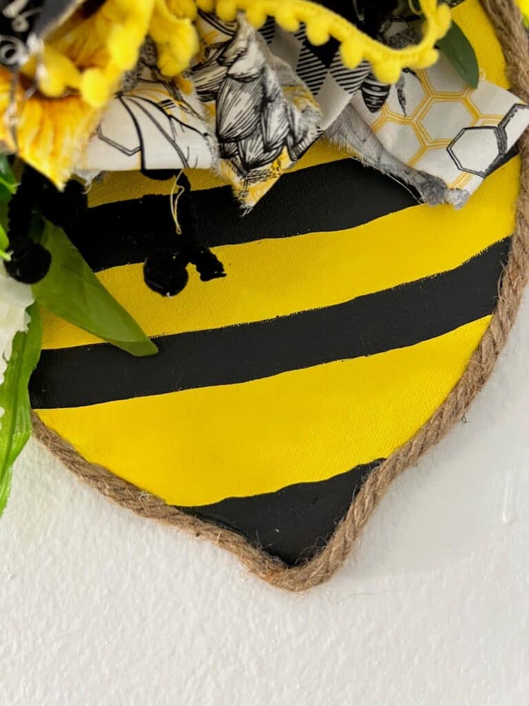 Close up of the bottom of the bees body with black and yellow stripes.