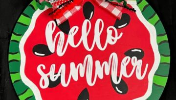 DIY Hello Summer Watermelon Door Hanger made with a wood round, a fabric bow, and white cricut vinyl to decorate your home front door.