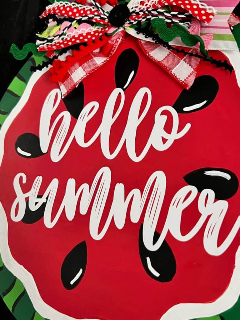 Close up of the center of the watermelon with cricut white vinyl that says "Hello Summer".