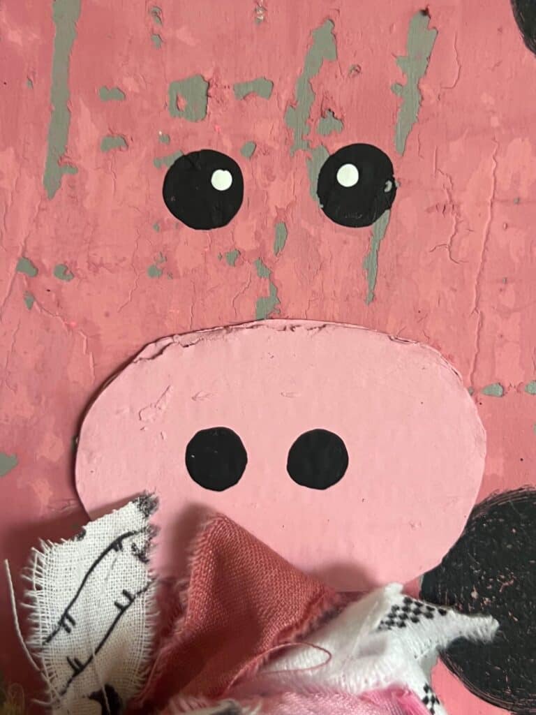 The pigs face with black dotted eyes and a cardboard snout.