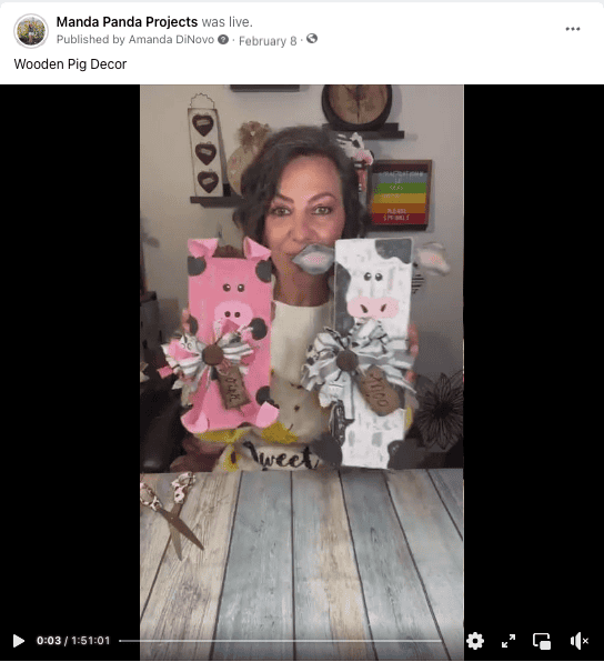 Amanda holding the completed pig project on a facebook live thumbnail along with a wood cow.