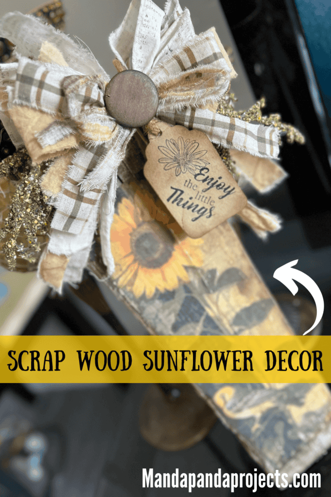 DIY Scrap wood sunflower decor with a free sunflower printable on rice paper, decoupaged onto a piece of scrap wood and a big messy fabric bow with a hangtag that says "enjoy the little things".