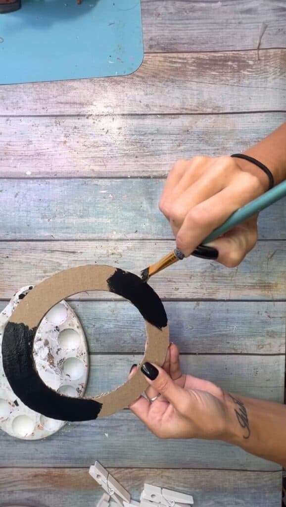 Painting the cardboard donut shape all black.