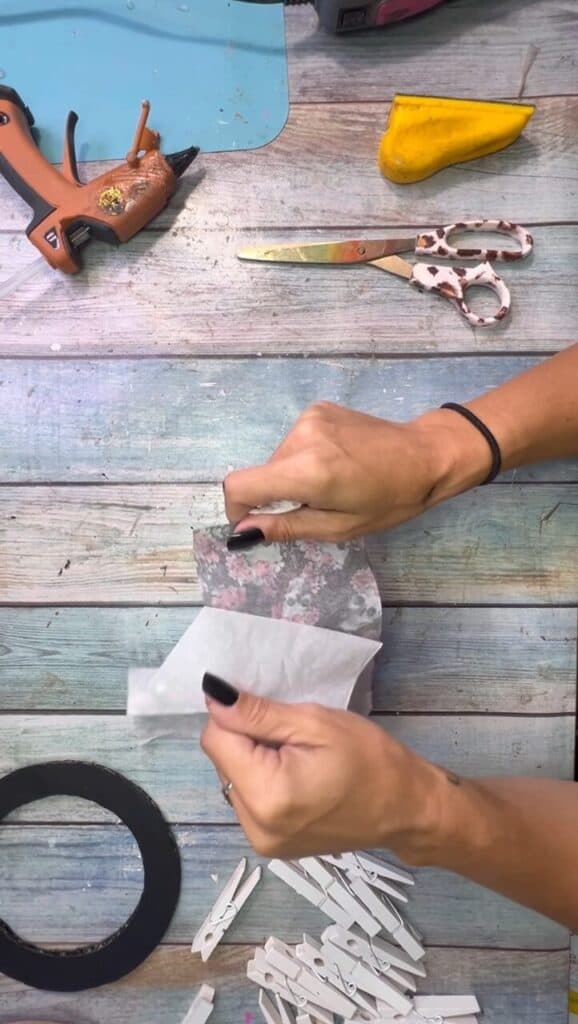 Peeling apart the plys if the floral skull napkin to attach to the clothespins for the Halloween wreath.