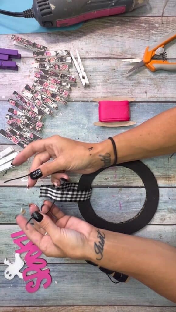 Tying buffalo check ribbon around the top of the cardboard donut to make a hanger.