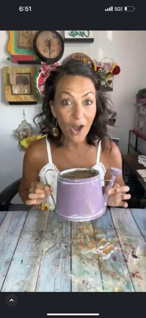 Amanda holding the purple thrifted watering can before it was remade into diy fall decor. 