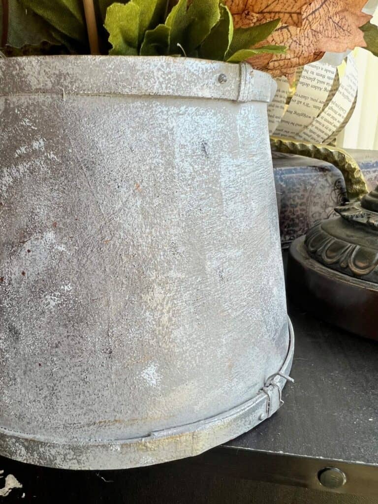 Closeup of the watering can painted to look like galvanized metal.