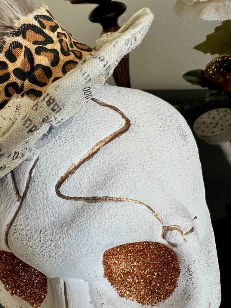 Close up of the skull painted white with gold in the cracks of the skull.