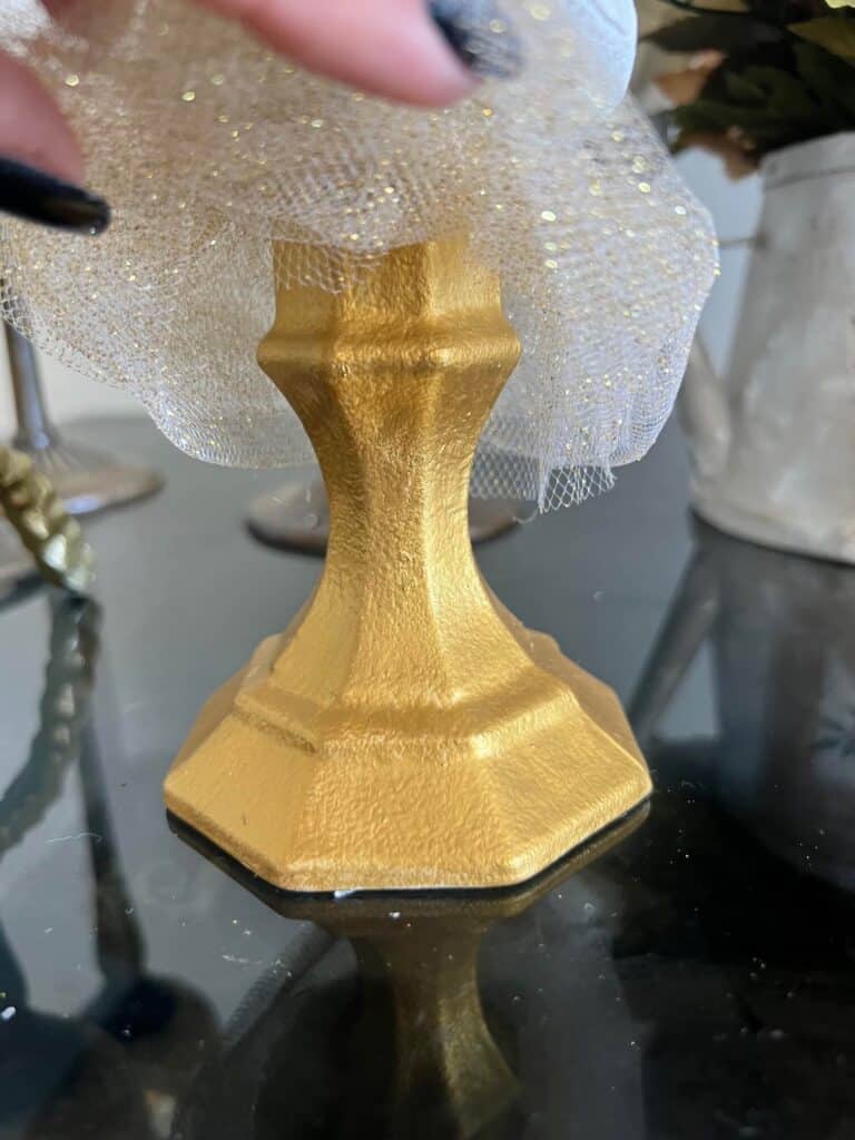 The glass candlestick is painted gold.