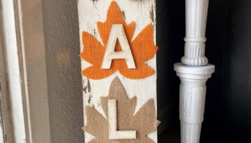 DIY Dollar tree long sign with 4 burlap fall leaves, one brown, orange, tan, and teal, that says FALL. The sign has a white chippy background perfect for decorating your home this autumn season.