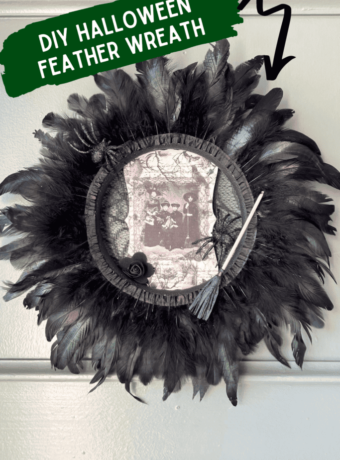 Dollar Tree styrofoam wreath form with black feather trim around the outside, vintage witches rice paper sign in the center, and embellished with faux spiders, mini broomstick, and a black rose for DIY Halloween crafts and decor.