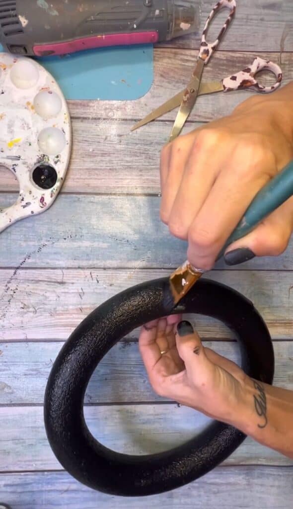 Painting the styrofoam wreath form all black.