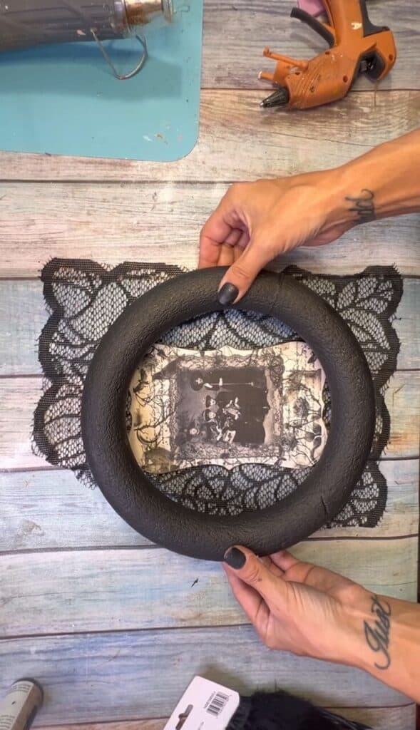 Gluing the black painted wreath form to the the black lace.