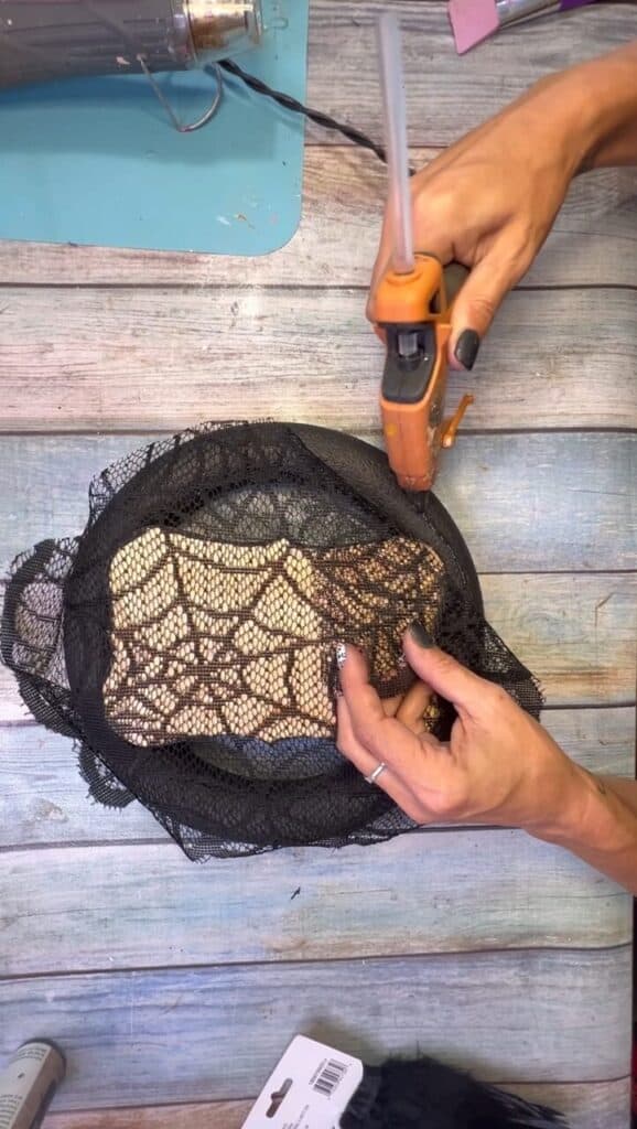 Gluing the black lace to the wreath form.