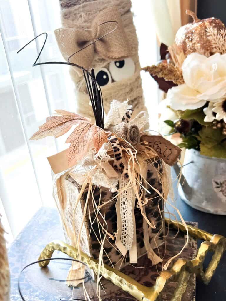 Scrap Wood Block Chunky Neutral Pumpkin with gold, leopard print, hymnal sheet, and a messy bow with a burlap flower and fall leaf embellishment.