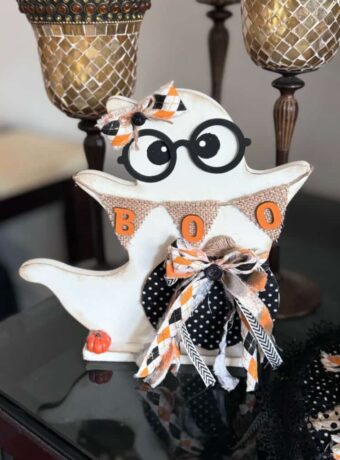 Thrifted Wood Ghost Makeover with black glasses and a burlap banner that says BOO.