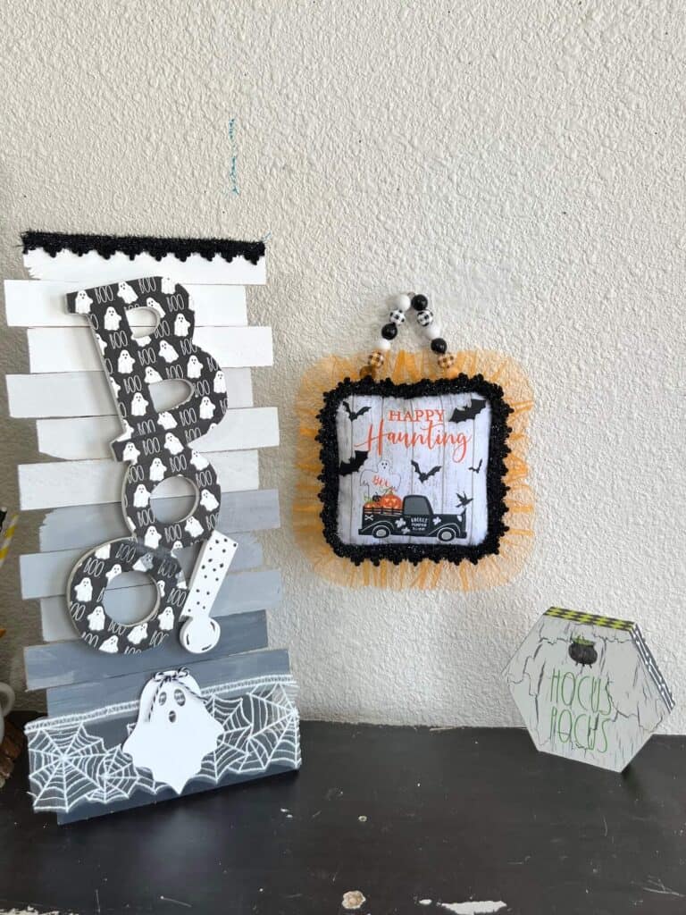 The completed halloweem doorknob hanger hanging on the wall next to a BOO and hocus pocus sign.