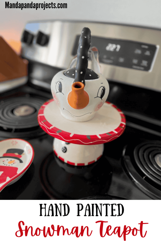 Thrifted Hand painted snowman teapot with the "spout" painted orange as the "carrot" nose, big black eyed, rosy pink cheeks, black and white polka dot handle, and a black, red, and white scrappy fabric bow on the handle.