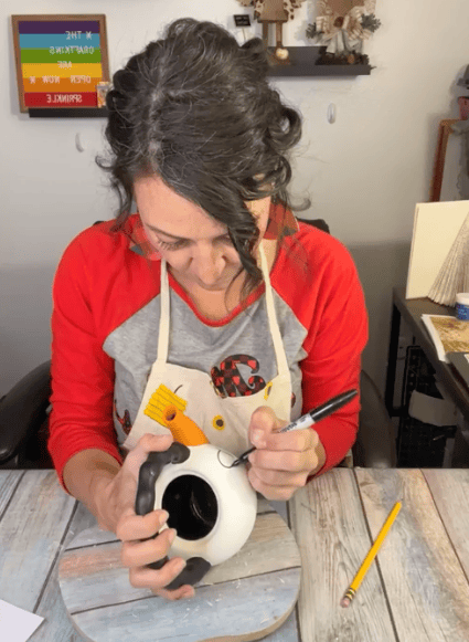 Amanda drawing over the penciled outline of the eyes with black Sharpie.