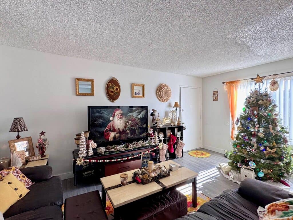 San Diego apartment living room decorated for Christmas in 2024 with vintage gold, white, and and maroon theme with santas, snowmen, christmas trees, Angels, and lots of gold!