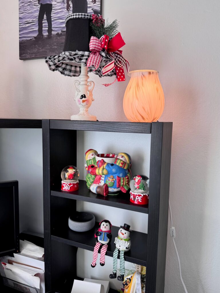 Thrifted hand painted snowman lamp on a desk.