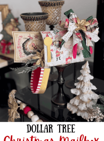 A dollar tree penguin cardboard mailbox that was made over for Christmas with a vintage santa napkin, some gold poinsettias, christmas greenery, and a messy fabric bow on a wood candlestick base for DIY decor.