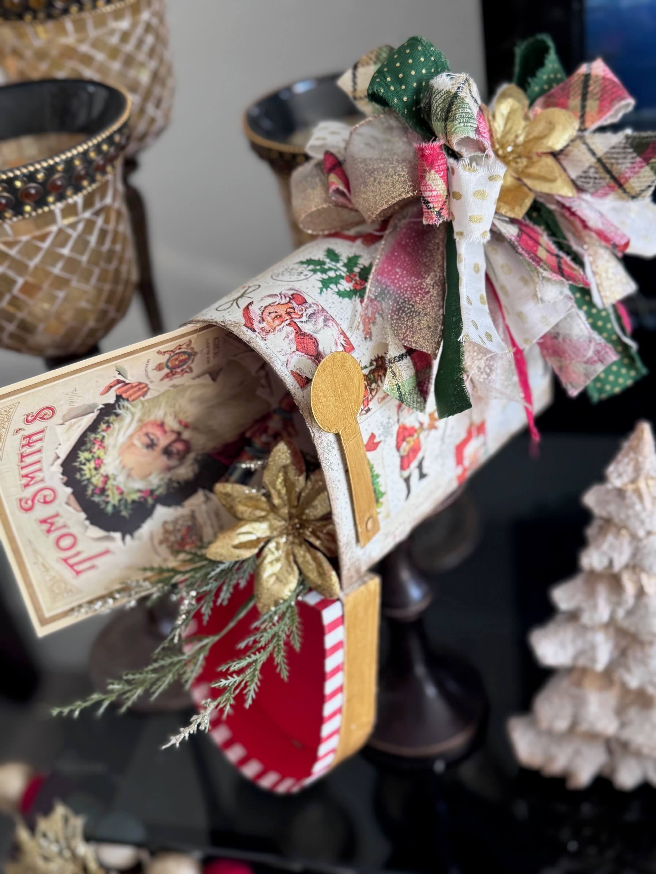 The top portion of the DIY mailbox showing the inside with a vintage Santa christmas card and greenery and poinsettia.