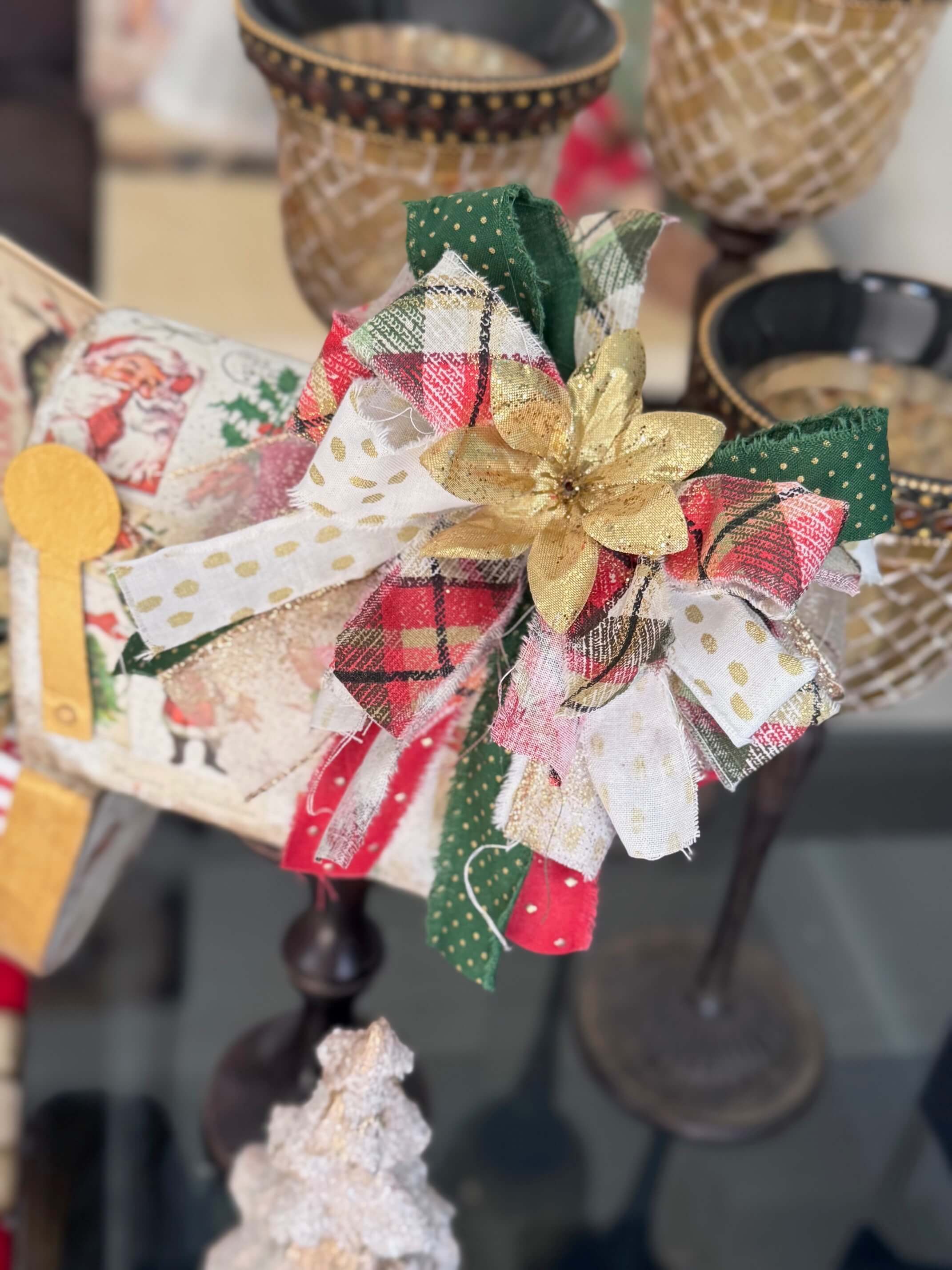 Green, red, and gold messy fabric bow with a gold poinsettia in the center.