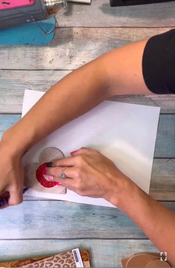 Tracing the wood hearts onto the scrapbook paper.