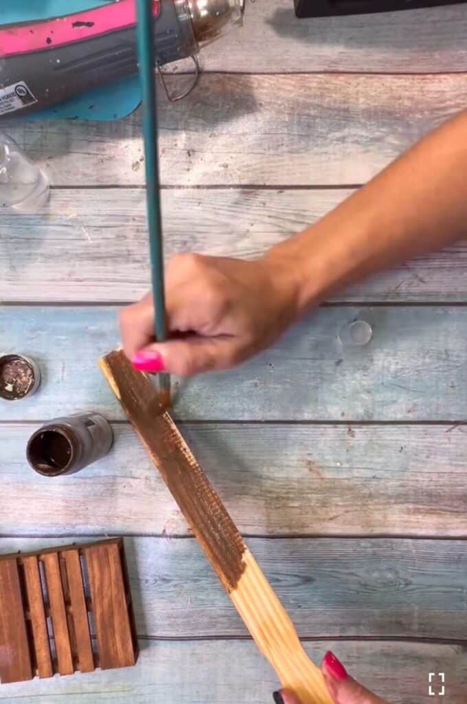 Staining the paint stick with antique wax.